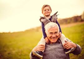 little boy riding on grandpa's shoulders