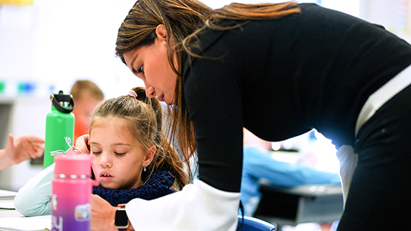 kindergarten teacher helps child