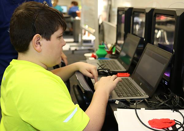 photo of boy using computers 