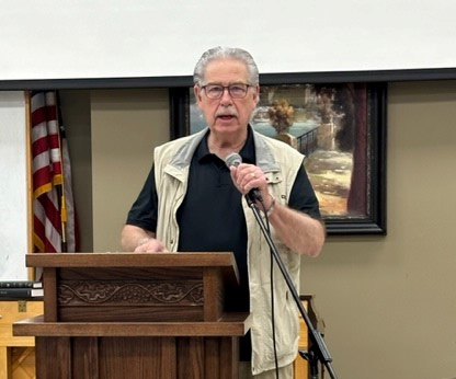 man standing at podium talking into microphone