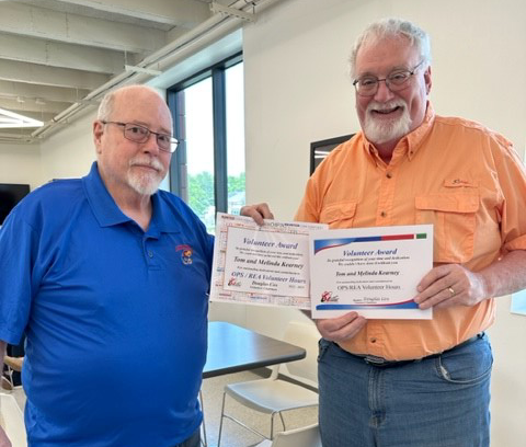 two men hold award certificates