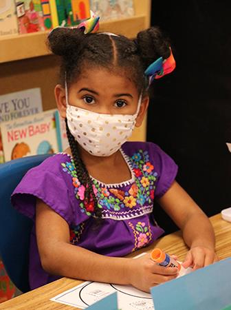 photo of girl drawing on paper