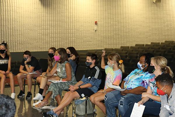 middle school students hold club meeting in auditorium