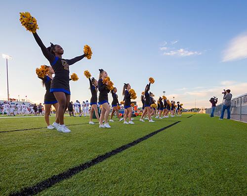 cheerleaders performing on football field