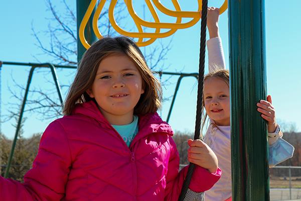 girls playing on playground equipment