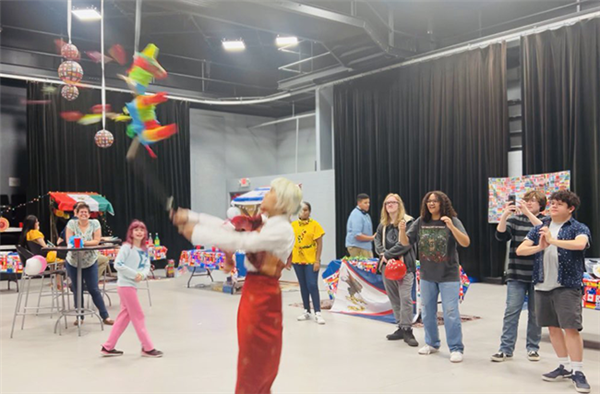 student swings at a pinatta